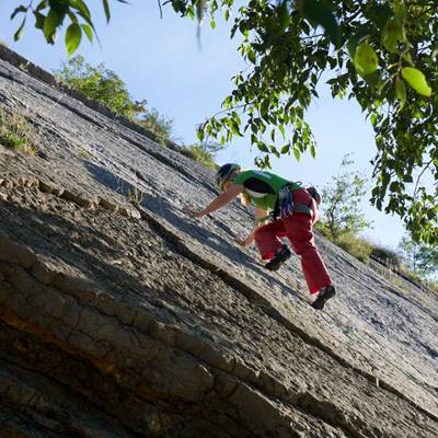 Klettern Ein Mann klettert an einer Felswand in Torbole am Gardasee